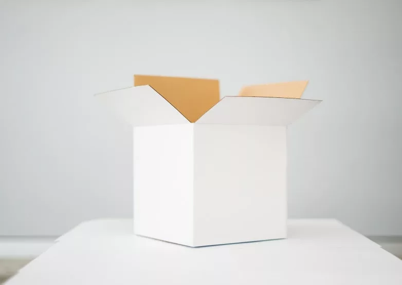 white carboard box with top opened on a white table