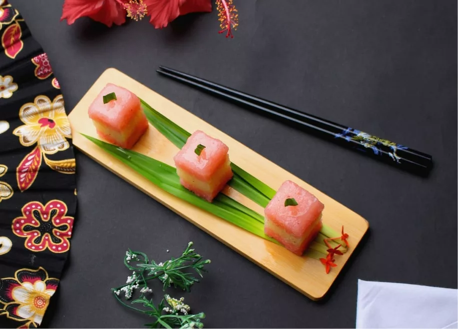 sushi cut in cubes on a small japanese cutting board